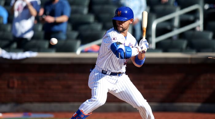 Mets right fielder Michael Conforto leans into a pitch in the strike zone. He was incorrectly awarded first base, which forced in the winning run against the Marlins.